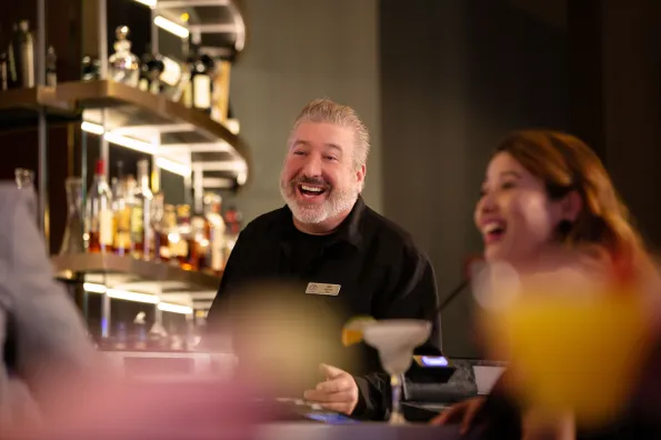 A happy bartender and guest at The Bar in Little River Casino Resort