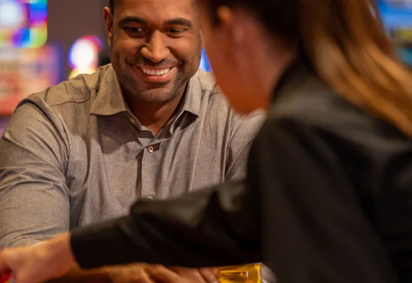man smiling at dealer during table game 
