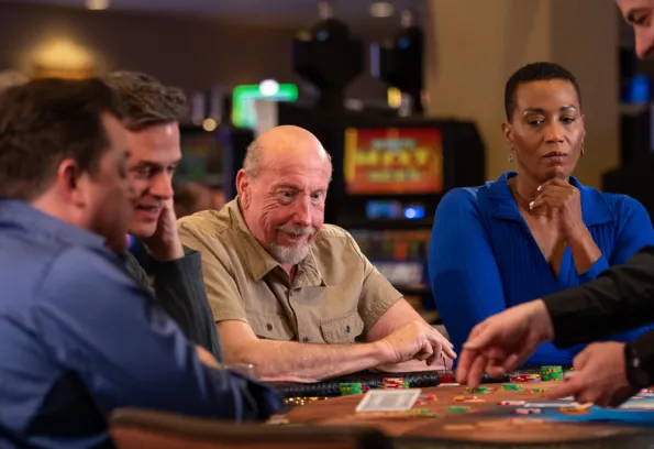 three men and a woman playing poker at Little River Casino