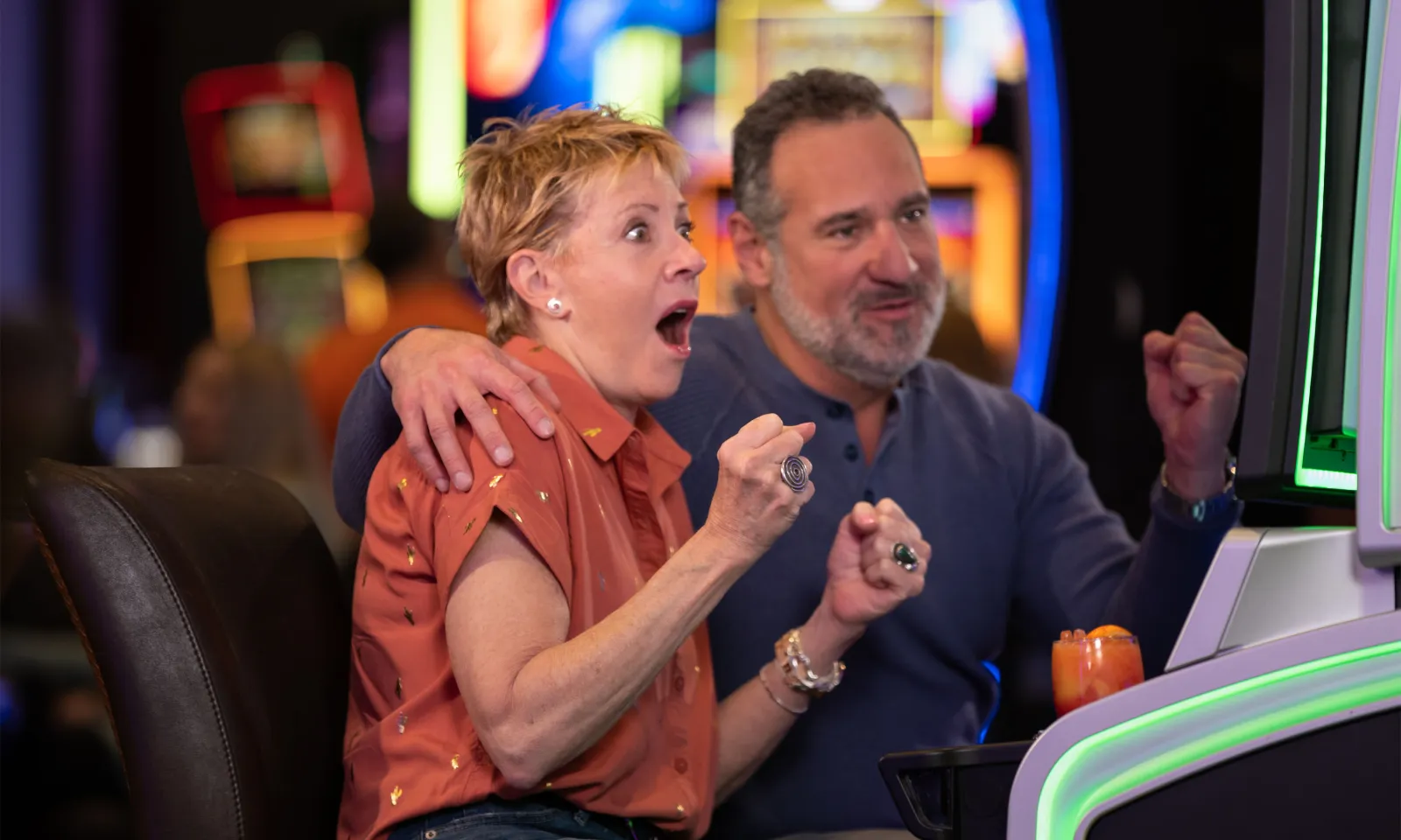 man and women staring surprised at a slot machine 