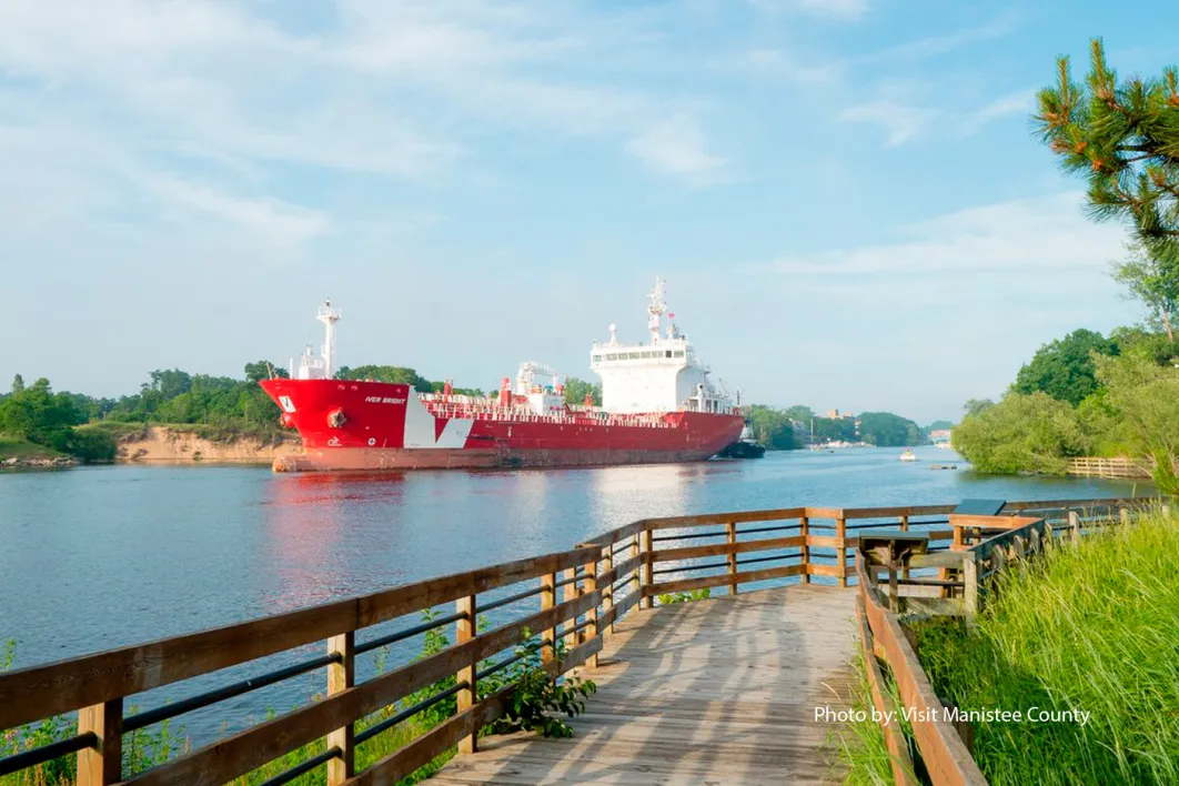 View of red ship along riverwalk in Manistee Michigan