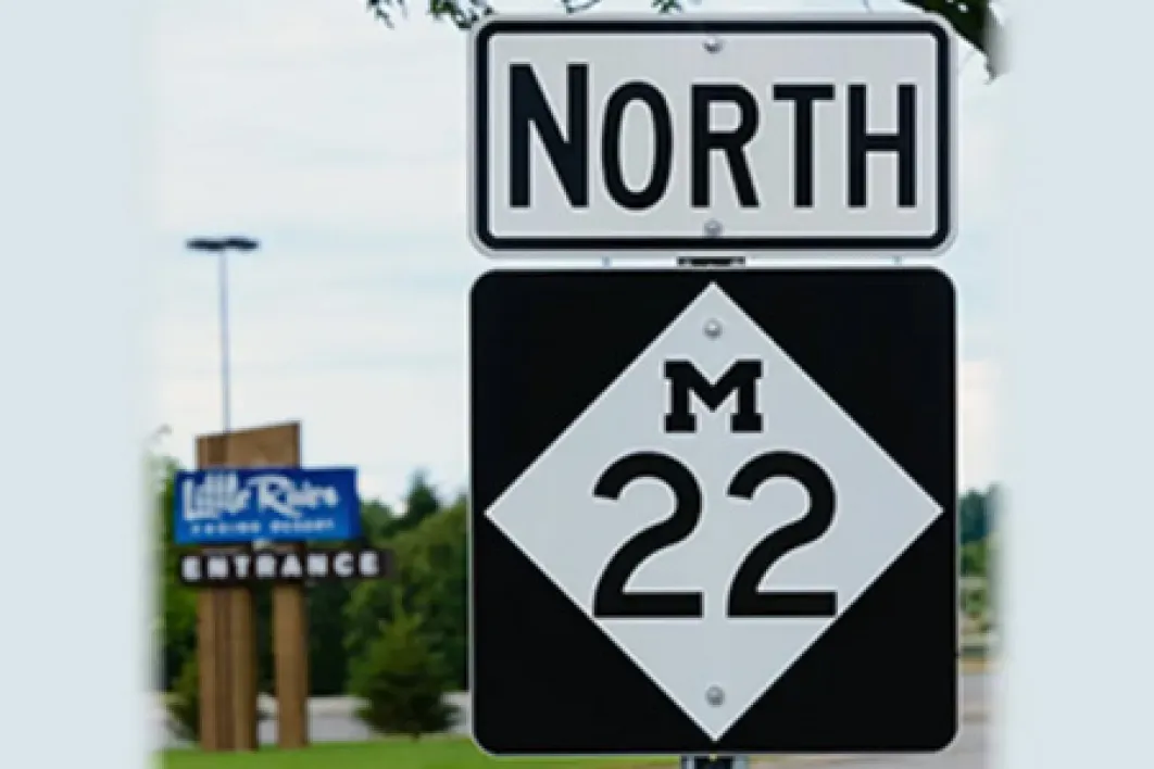 North M-22 Highway Sign with Little River entrance sign in the background