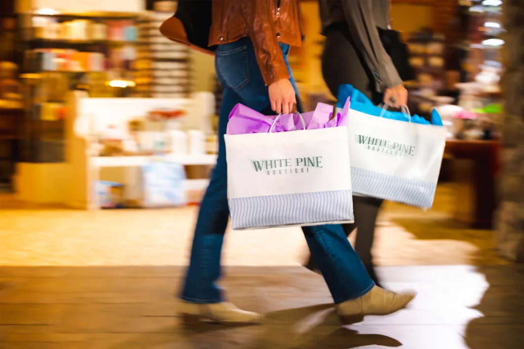 two women walking with White Pine Boutique bags 